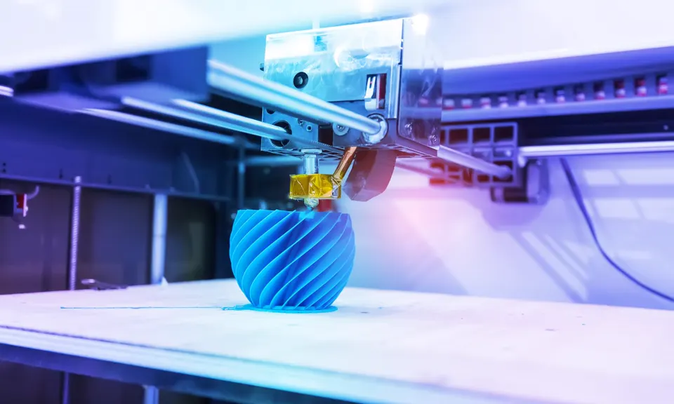 3D printer producing a small blue model