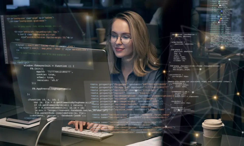 Developer working at a laptop with code graphics overlaid